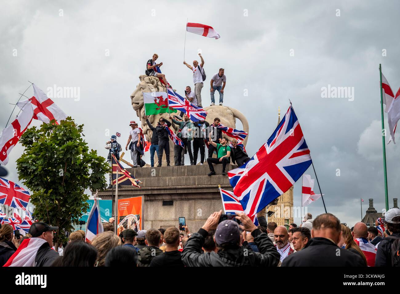 Manifestants sur l'un des lions sur le pont de Westminster, la marche « Unite the Kingdom » menée par Tommy Robinson rassemble des centaines de milliers de manifestants en cent Banque D'Images