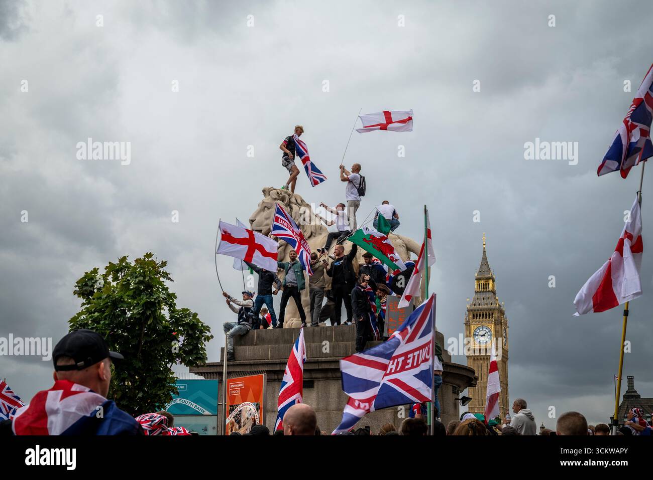 Manifestants sur l'un des lions sur le pont de Westminster, la marche « Unite the Kingdom » menée par Tommy Robinson rassemble des centaines de milliers de manifestants en cent Banque D'Images