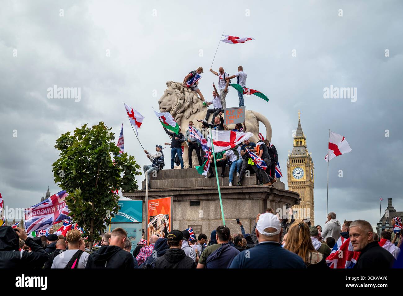 Manifestants sur l'un des lions sur le pont de Westminster, la marche « Unite the Kingdom » menée par Tommy Robinson rassemble des centaines de milliers de manifestants en cent Banque D'Images
