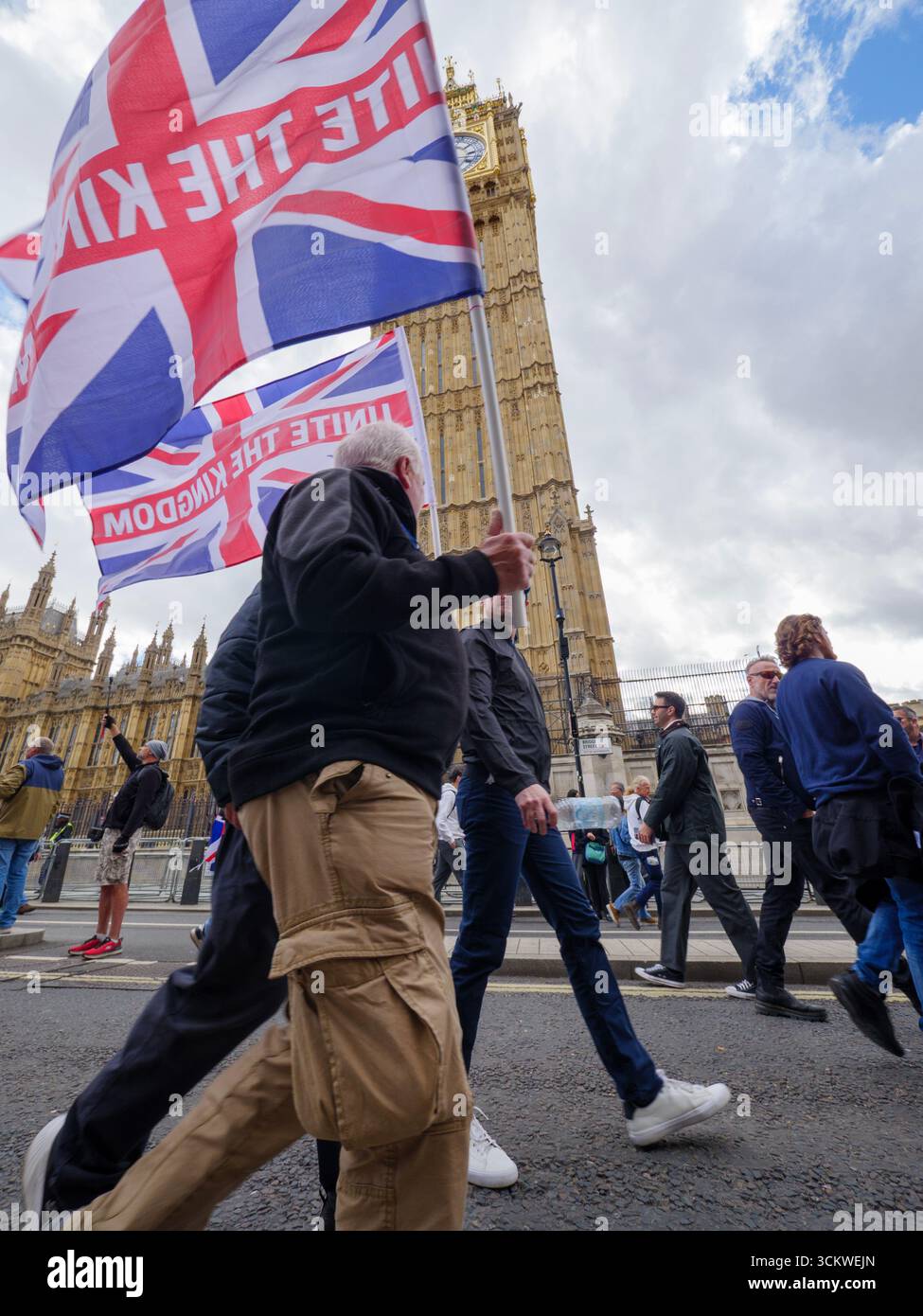 Manifestation unite the Kingdom, 13 septembre 2025, Westminster, Londres, Royaume-Uni. Des manifestants arborant le drapeau de l'Union Jack défilent dans le centre de Londres devant Big Ben Westminster lors d'une manifestation organisée par Tommy Robinson Banque D'Images
