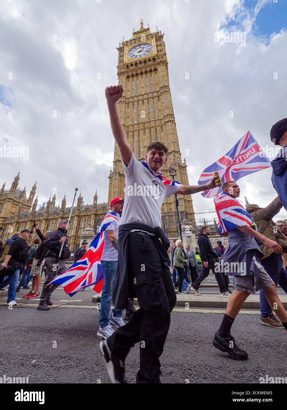 Manifestation unite the Kingdom, 13 septembre 2025, Westminster, Londres, Royaume-Uni. Des manifestants arborant le drapeau de l'Union Jack défilent dans le centre de Londres devant Big Ben Westminster lors d'une manifestation organisée par Tommy Robinson Banque D'Images
