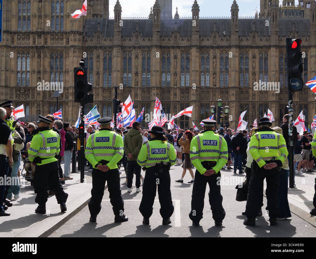 Manifestation unite the Kingdom, 13 septembre 2025, Westminster, Londres, Royaume-Uni. Des manifestants arborant les drapeaux de l'Union Jack et de St George défilent dans le centre de Londres devant les chambres du Parlement lors d'une manifestation organisée par Tommy Robinson, alors que les policiers forment un cordon Banque D'Images