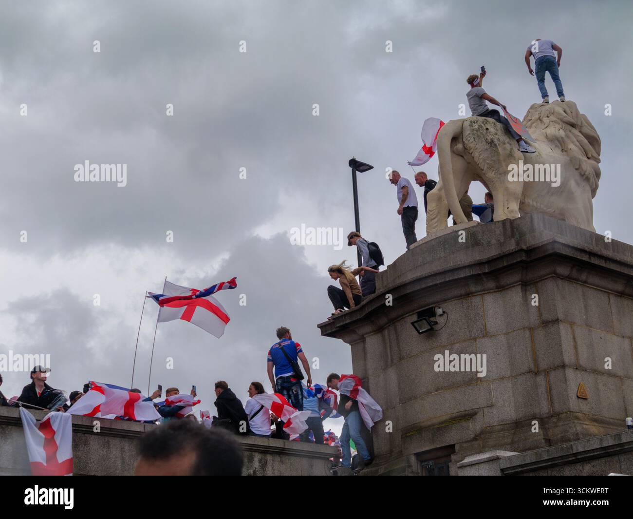 Manifestation unite the Kingdom, 13 septembre 2025, Westminster, Londres, Royaume-Uni. Des manifestants arborant les drapeaux de l'Union Jack et de St George grimpent le Lion de South Bank sur le pont de Westminster dans le centre de Londres lors d'une manifestation organisée par Tommy Robinson Banque D'Images