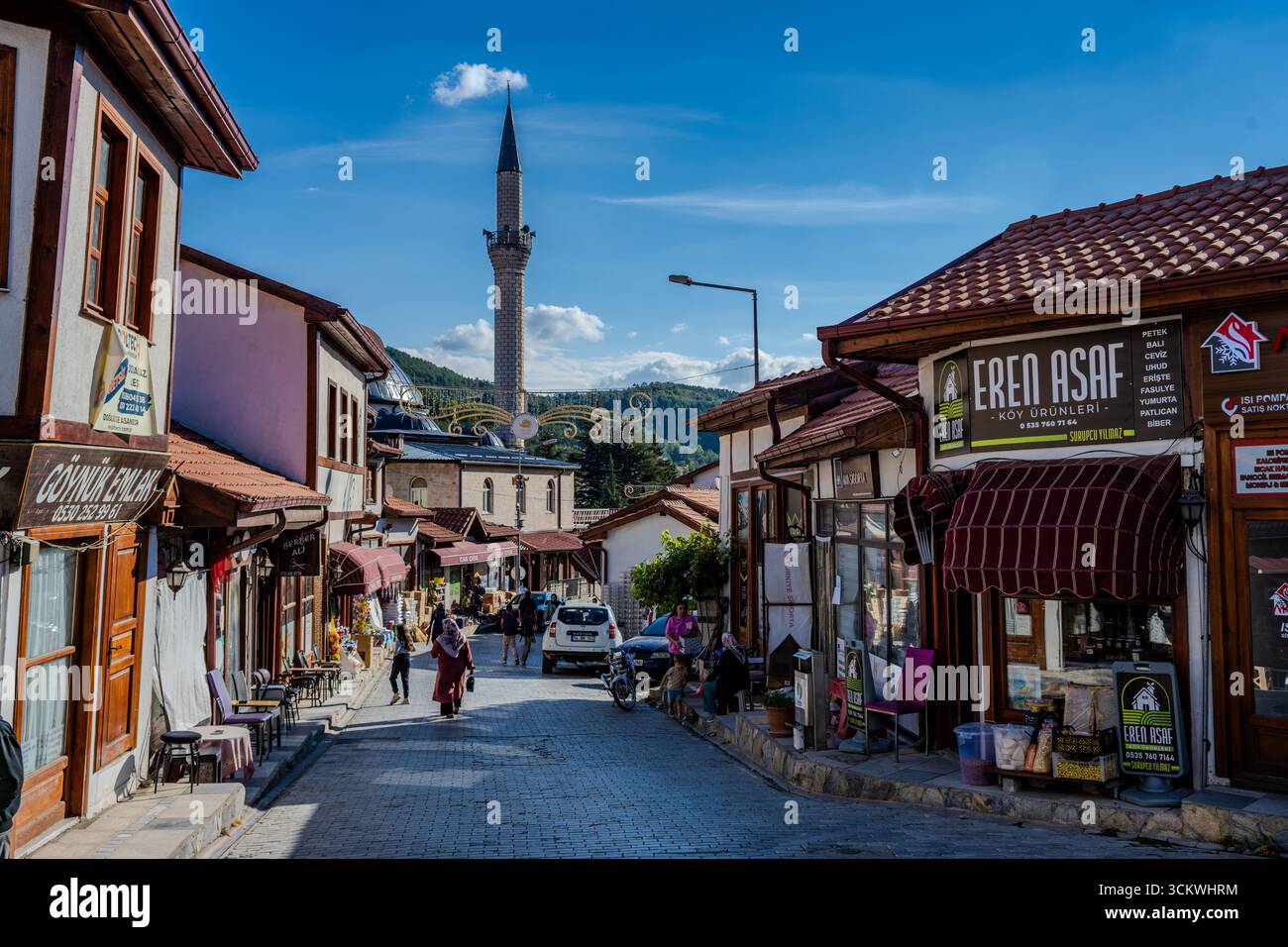 Les gens marchent le long d'une rue traditionnelle de style ottoman avec des boutiques et une vue sur la mosquée Gazi Süleyman Pacha dans la ville historique de Göynük, Bolu Provi Banque D'Images
