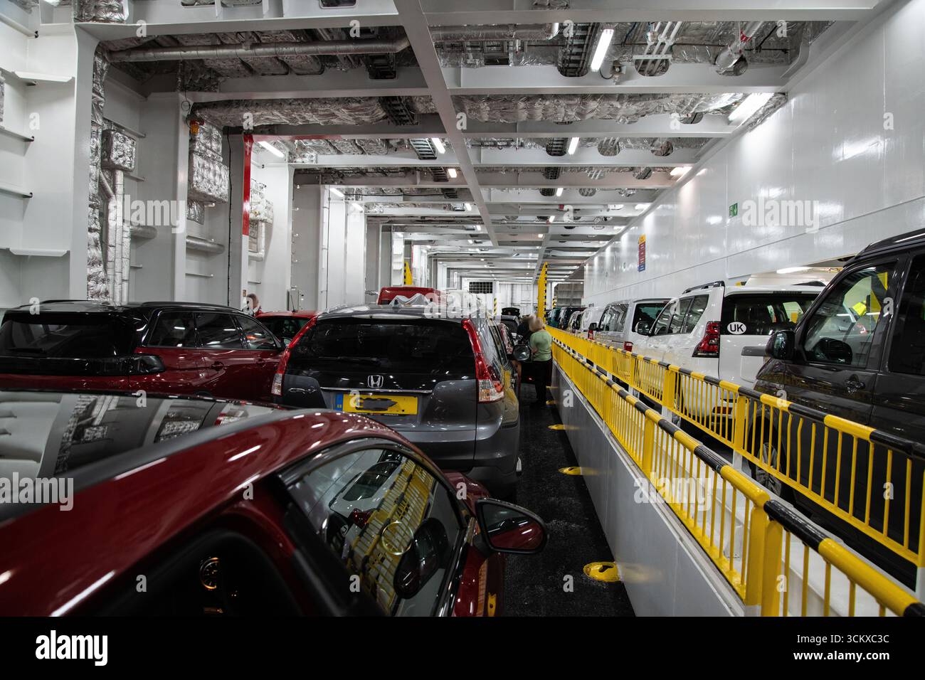Pont de voitures sur un ferry traversant la Manche naviguant de Portsmouth à Caen, montrant des véhicules stationnés à l'intérieur industriel du navire, une scène européenne Banque D'Images