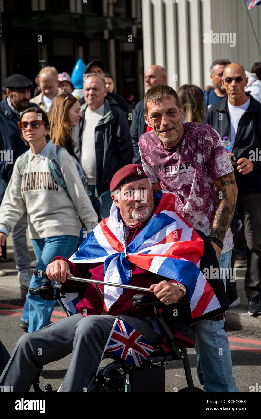 Vétéran en fauteuil roulant, la marche « Unite the Kingdom » dirigée par Tommy Robinson rassemble des centaines de milliers de manifestants dans le centre de Londres, Angleterre, Royaume-Uni, 13e. Banque D'Images