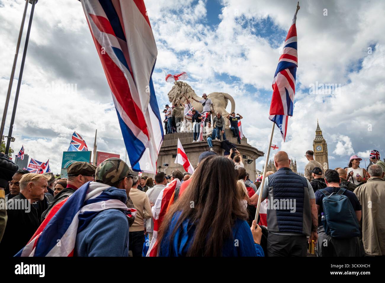 Protestataires au sommet d'un lion sur le pont de Westminster, la marche "Unite the Kingdom" menée par Tommy Robinson rassemble des centaines de milliers de manifestants en Centra Banque D'Images