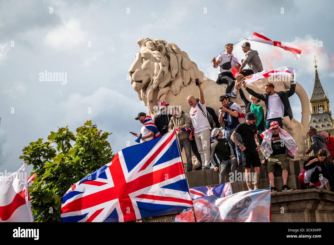 Protestataires au sommet d'un lion sur le pont de Westminster, la marche "Unite the Kingdom" menée par Tommy Robinson rassemble des centaines de milliers de manifestants en Centra Banque D'Images