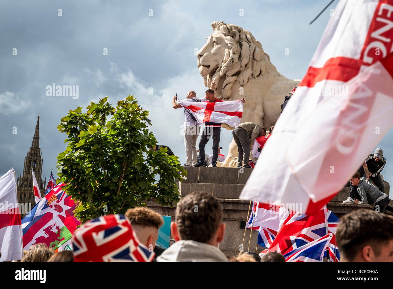 Protestataires au sommet d'un lion sur le pont de Westminster, la marche "Unite the Kingdom" menée par Tommy Robinson rassemble des centaines de milliers de manifestants en Centra Banque D'Images