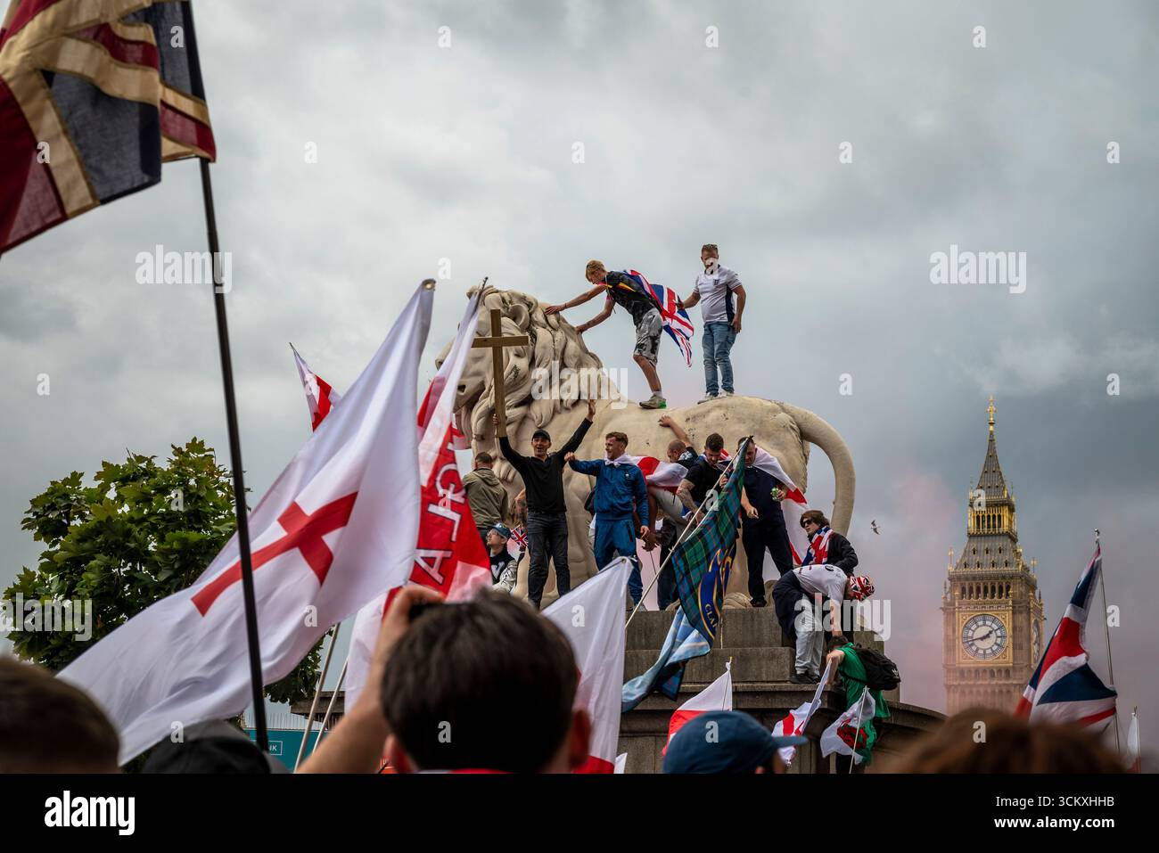 Protestataires au sommet d'un lion sur le pont de Westminster, la marche "Unite the Kingdom" menée par Tommy Robinson rassemble des centaines de milliers de manifestants en Centra Banque D'Images