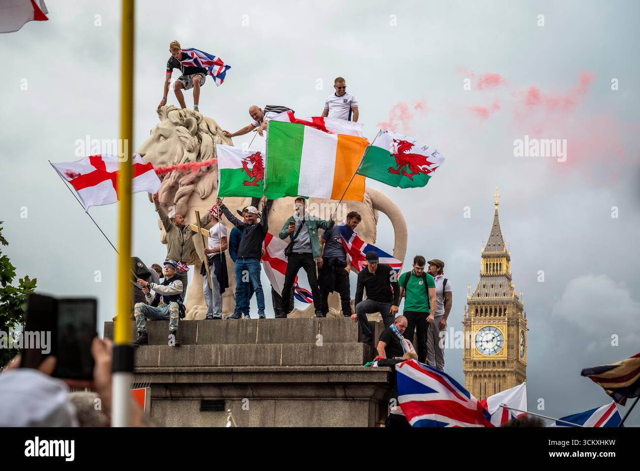 Protestataires au sommet d'un lion sur le pont de Westminster, la marche "Unite the Kingdom" menée par Tommy Robinson rassemble des centaines de milliers de manifestants en Centra Banque D'Images