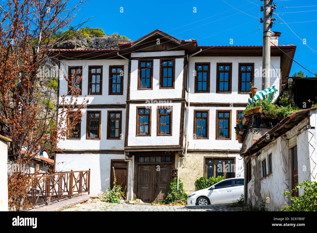 Une maison traditionnelle de l'époque ottomane avec des détails en bois et des murs blanchis à la chaux se dresse le long d'une rue pavée à Mudurnu, Bolu, Turquie. Banque D'Images