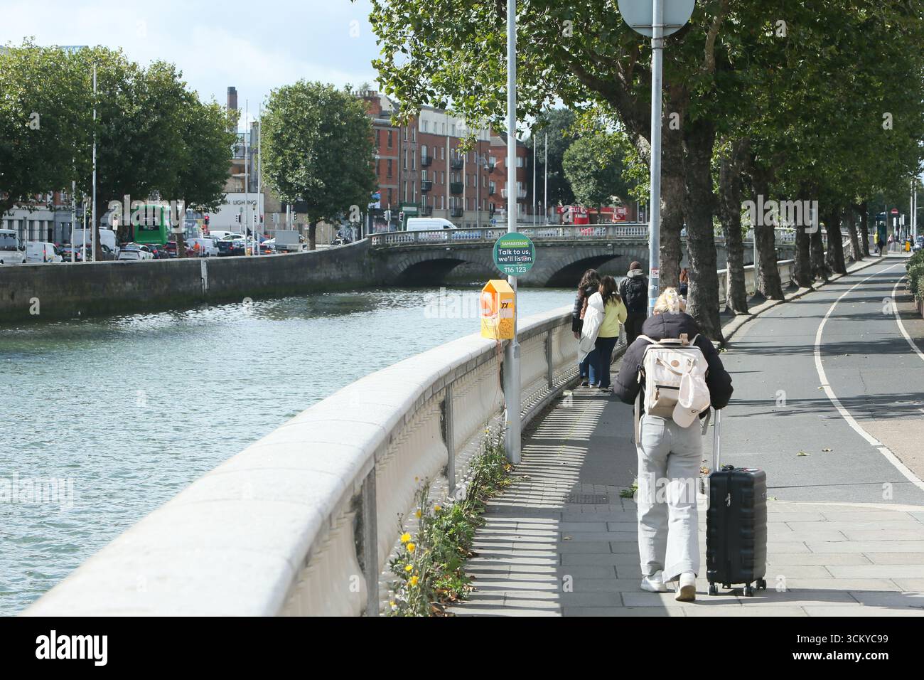 Dublin, Irlande - 12 septembre 2025 - Une vue d'Inns Quay dans le centre-ville de Dublin alors qu'une femme voyage avec une valise à roulettes de voyage par un après-midi ensoleillé dans la capitale irlandaise Banque D'Images