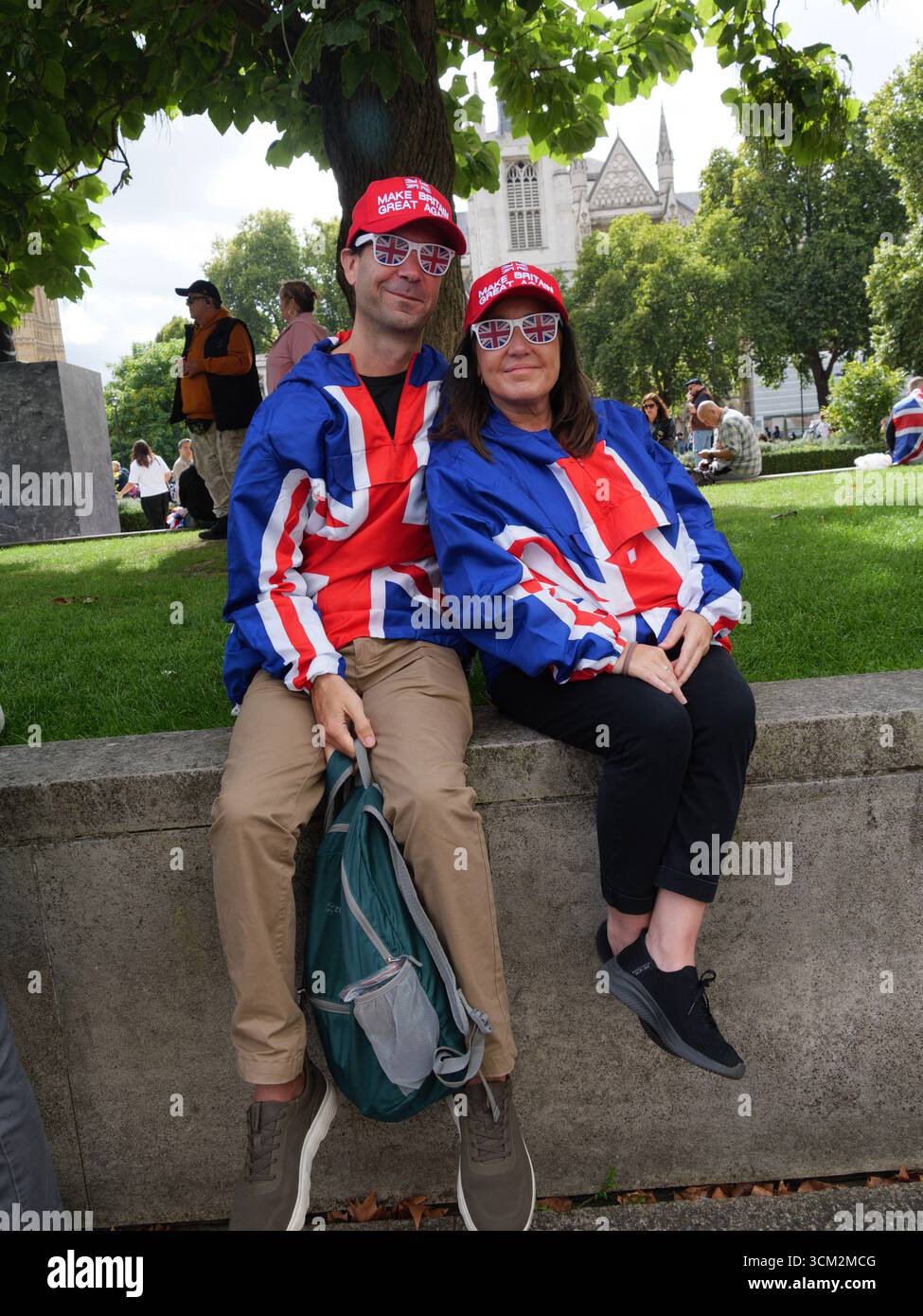 Manifestation unite the Kingdom, 13 septembre 2025, Westminster, Londres, Royaume-Uni. Des manifestants avec drapeau de l'Union, vêtements de l'Union Jack, lunettes et chapeau « Make Britain Great Again » posent pour une photo dans le centre de Londres lors d'une manifestation organisée par Tommy Robinson Banque D'Images
