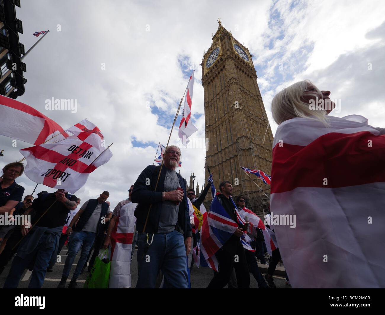 Manifestation unite the Kingdom, 13 septembre 2025, Westminster, Londres, Royaume-Uni. Des manifestants arborant les drapeaux de l'Union Jack et de St George défilent dans le centre de Londres, devant Big Ben et le Parlement lors d'une manifestation organisée par Tommy Robinson Banque D'Images