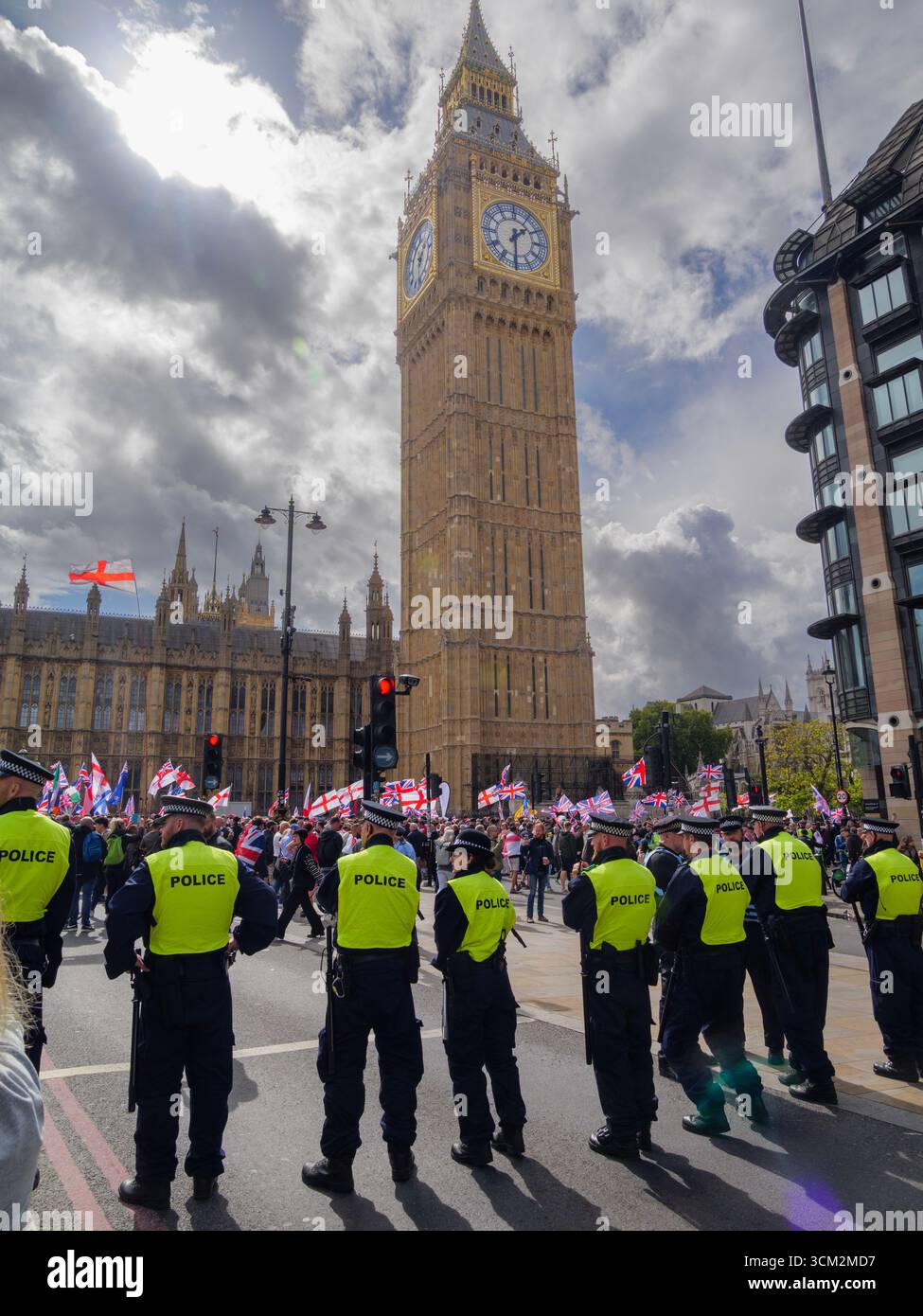 Manifestation unite the Kingdom, 13 septembre 2025, Westminster, Londres, Royaume-Uni. Des manifestants arborant les drapeaux de l'Union Jack et de St George défilent dans le centre de Londres devant Big Ben lors d'une manifestation organisée par Tommy Robinson, avec des policiers formant un cordon. Banque D'Images