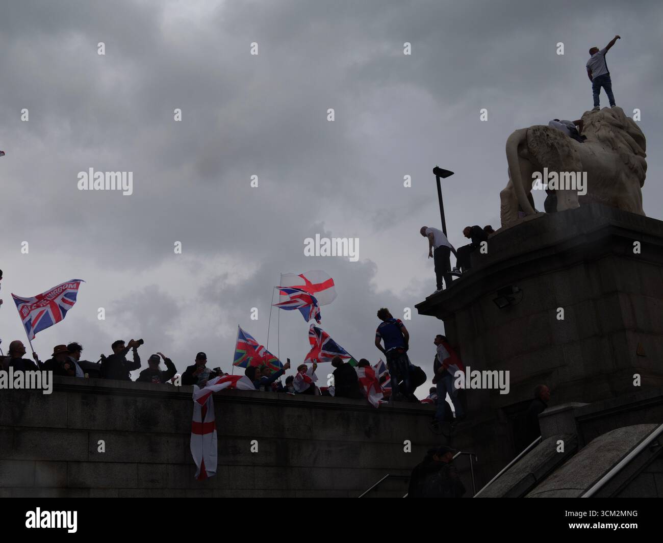 Manifestation unite the Kingdom, 13 septembre 2025, Westminster, Londres, Royaume-Uni. Des manifestants arborant les drapeaux de l'Union Jack et de St George grimpent le Lion de South Bank sur le pont de Westminster dans le centre de Londres lors d'une manifestation organisée par Tommy Robinson Banque D'Images
