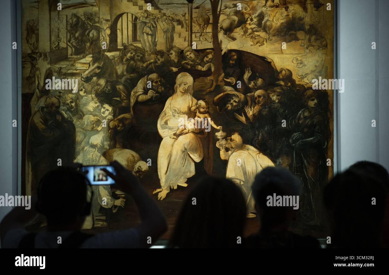 Visiteurs photographiant la peinture inachevée de Léonard de Vinci « Adoration des Mages » avec des smartphones modernes dans la Galerie des Offices, Florence, Italie, HIG Banque D'Images