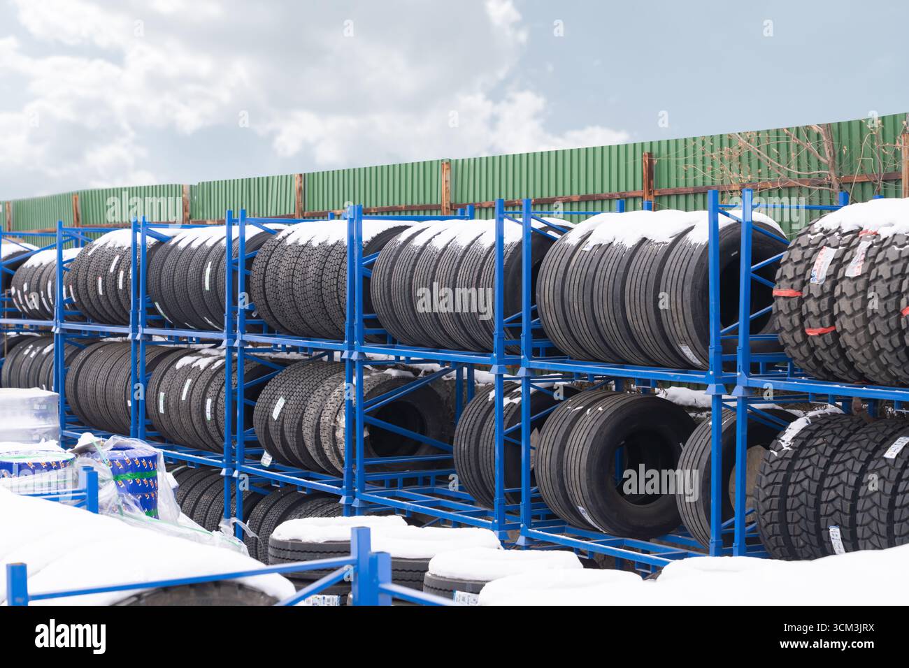 Les pneus de camion sont entreposés à l'extérieur dans la rue, recouverts de neige. Problème de stockage des pneus. Les pneus se détériorent-ils pendant le stockage à long terme et perdent-ils leur p Banque D'Images