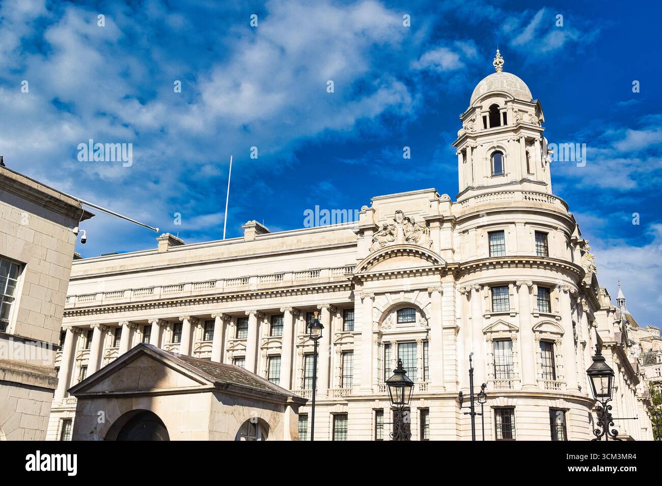 Un grand bâtiment orné avec une tour en forme de dôme, situé contre un ciel bleu vibrant avec des nuages blancs. L'architecture présente des colonnes classiques A. Banque D'Images