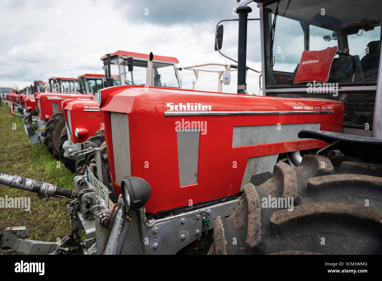 Logo et signalisation sur le capot d'un tracteur Schlüter rouge devant d'autres camions Schlüter historiques, Hallbergmoos, Bavière, Allemagne Banque D'Images