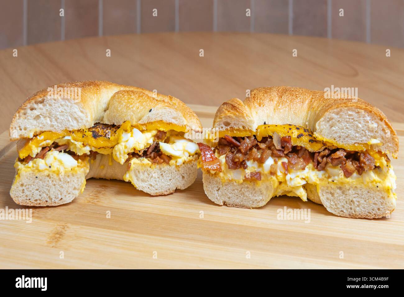Sandwich au bacon et aux œufs : bacon croustillant, œuf frit et fromage cheddar sur pain grillé beurré Banque D'Images Sandwich au bacon et aux œufs : bacon croustillant, œuf frit et fromage cheddar sur pain grillé beurré Banque D'Images