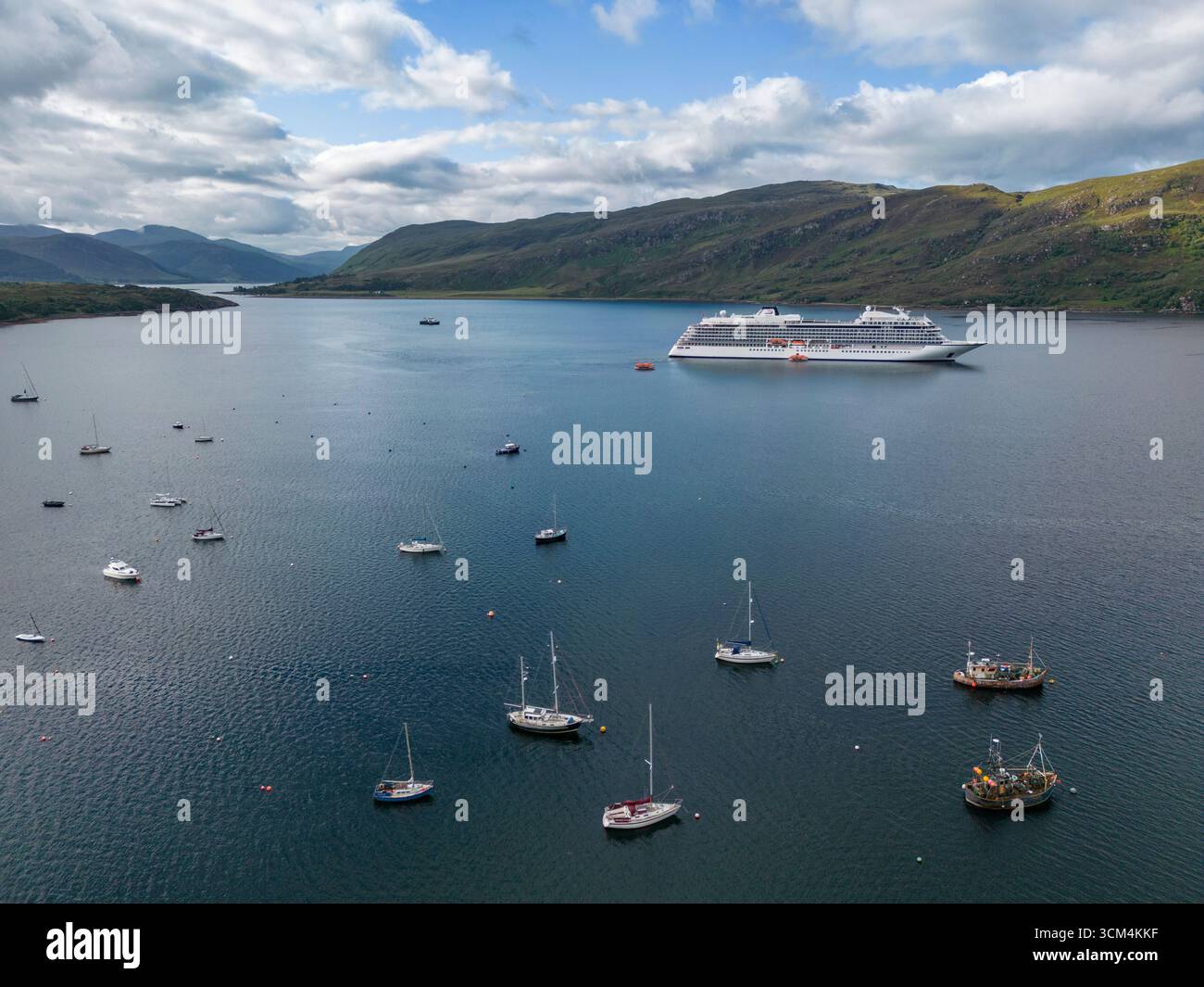 Vue aérienne du navire de croisière Viking Vela (Viking Cruises) amarré à Loch Broom avec des bateaux de pêche et des voiliers au premier plan, Ullapool, Hig Banque D'Images
