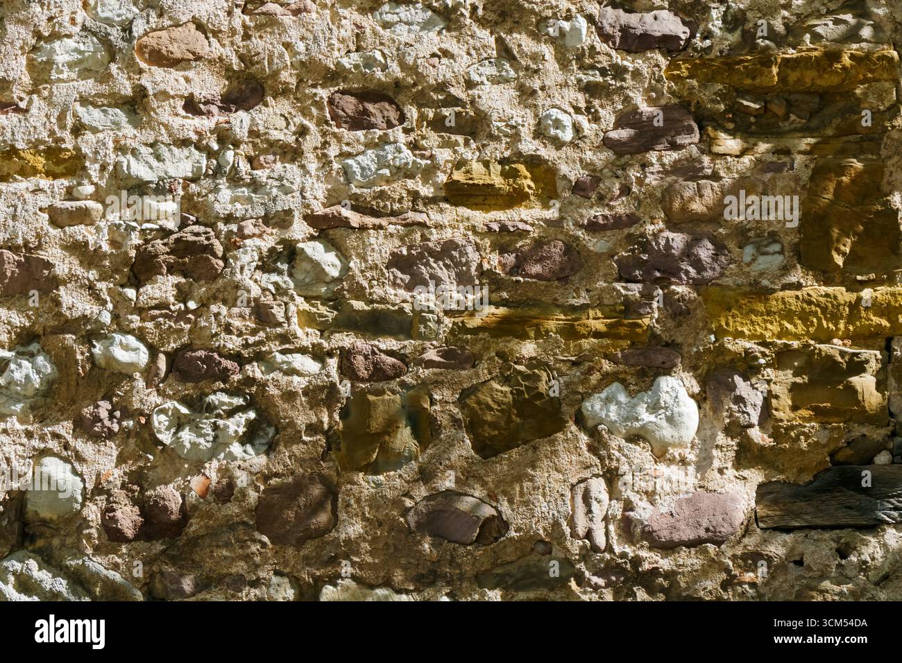 Gros plan d'un vieux mur de pierre construit avec des roches irrégulières et du mortier, montrant une texture rugueuse et des détails rustiques, parfait pour les arrière-plans, les projets de conception Banque D'Images
