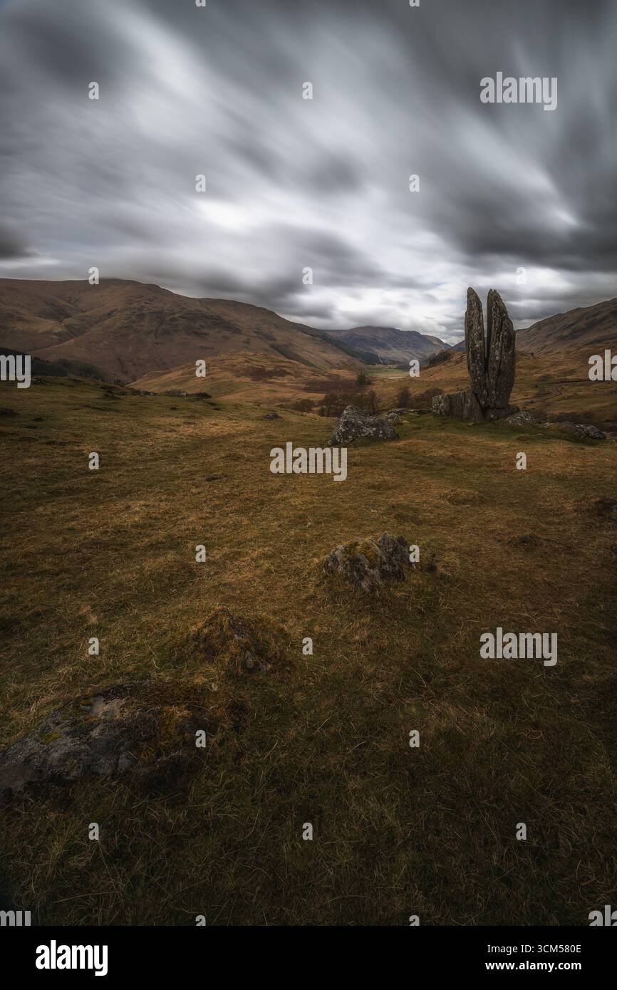 La formation rocheuse des mains priantes de Mary se dresse dans le paysage des Highlands écossais. Des nuages sombres se dessinent dans le ciel. Banque D'Images