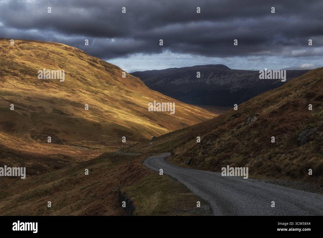 Une petite route serpente à travers les montagnes des Highlands écossais. Banque D'Images