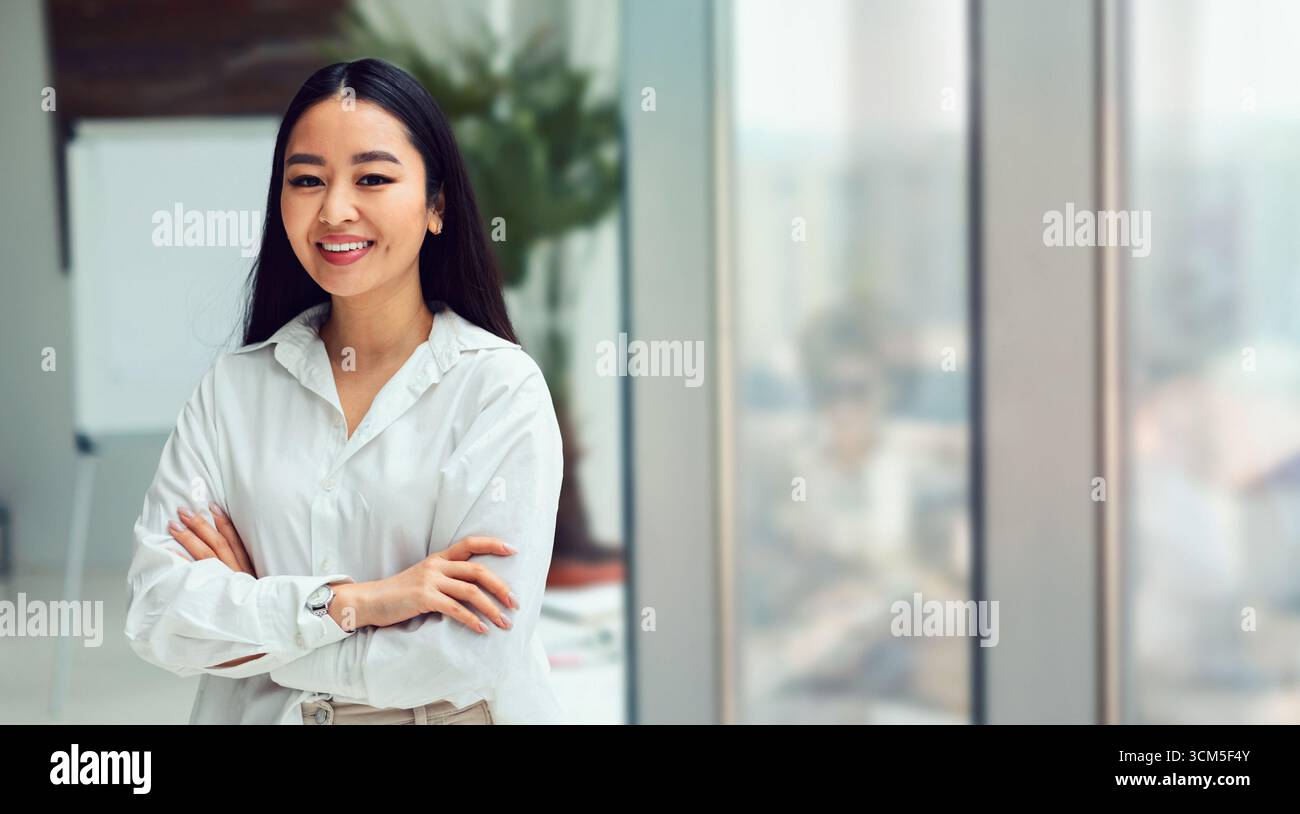 Femme d'affaires coréenne souriant debout lors d'une réunion d'entreprise dans un bureau moderne Banque D'Images