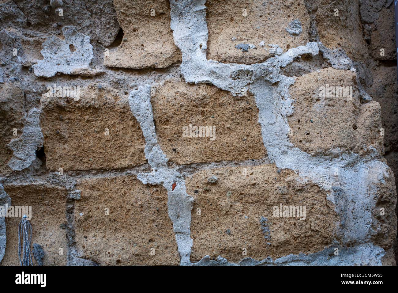 Gros plan d'un bloc de tuf et d'un mur de béton, typique de certains bâtiments. Fond et texture de base. Banque D'Images