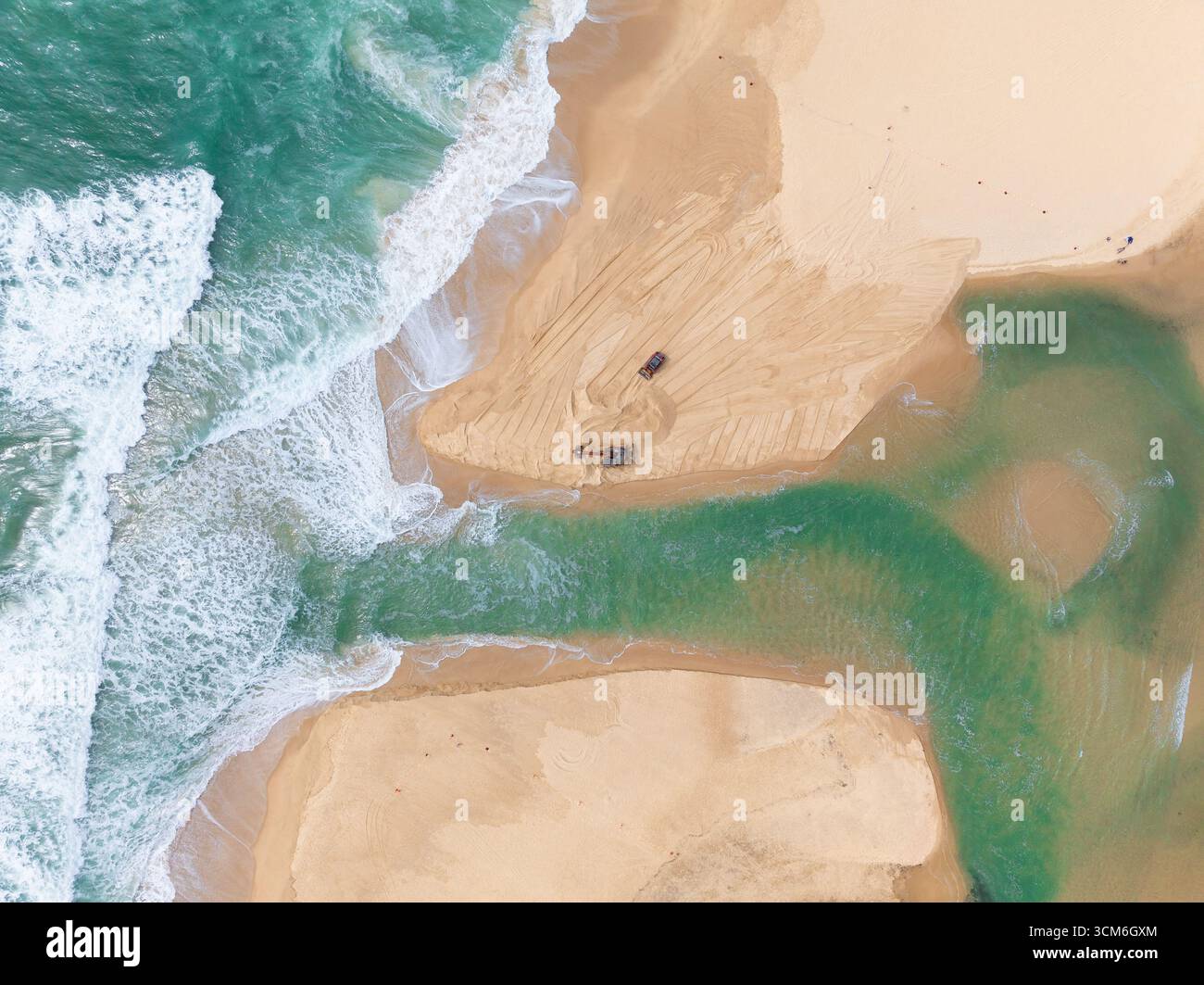 Vue aérienne d'engins de terrassement ouvrant un canal d'eau d'un lac à l'océan à Currimundi sur le Sunshine Caost dans le Queensland, Australie Banque D'Images