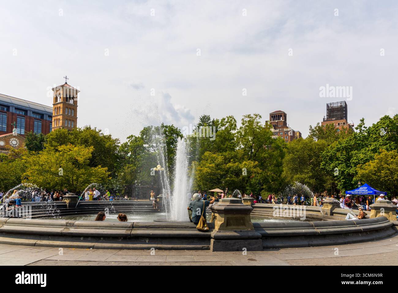 New York City, New York - 6 septembre 2025 : les gens visitent et apprécient le Washington Square Park autour de la fontaine. Banque D'Images