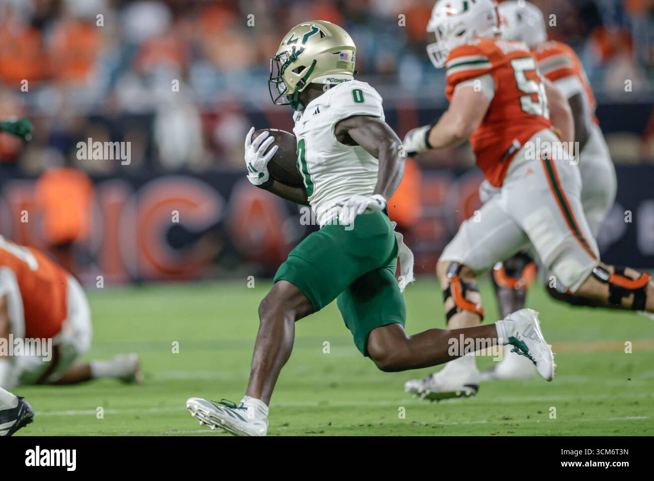 Miami, FL : Cornerback Jarvis Lee (0) des Bulls du sud de la Floride intercepte] le quarterback Carson Beck (11) des Hurricanes de Miami lors d'un match de la NCAA le samedi 13 septembre 2025 au Hard Rock Stadium. Les Hurricanes ont battu les Bulls 49-12. (Kim Hukari/image du sport) Banque D'Images