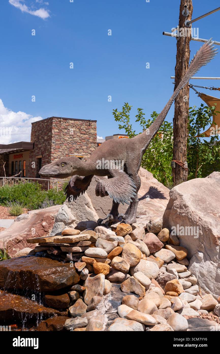 Réplique grandeur nature d'un dinosaure rapace droméosauridé sur une chute d'eau au Moab Giants Dinosaur Park, Moab, Utah. Banque D'Images