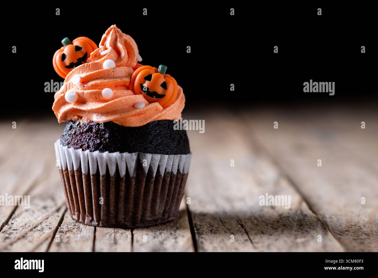 Cupcakes d'Halloween avec décoration de citrouille sur une table en bois rustique Banque D'Images