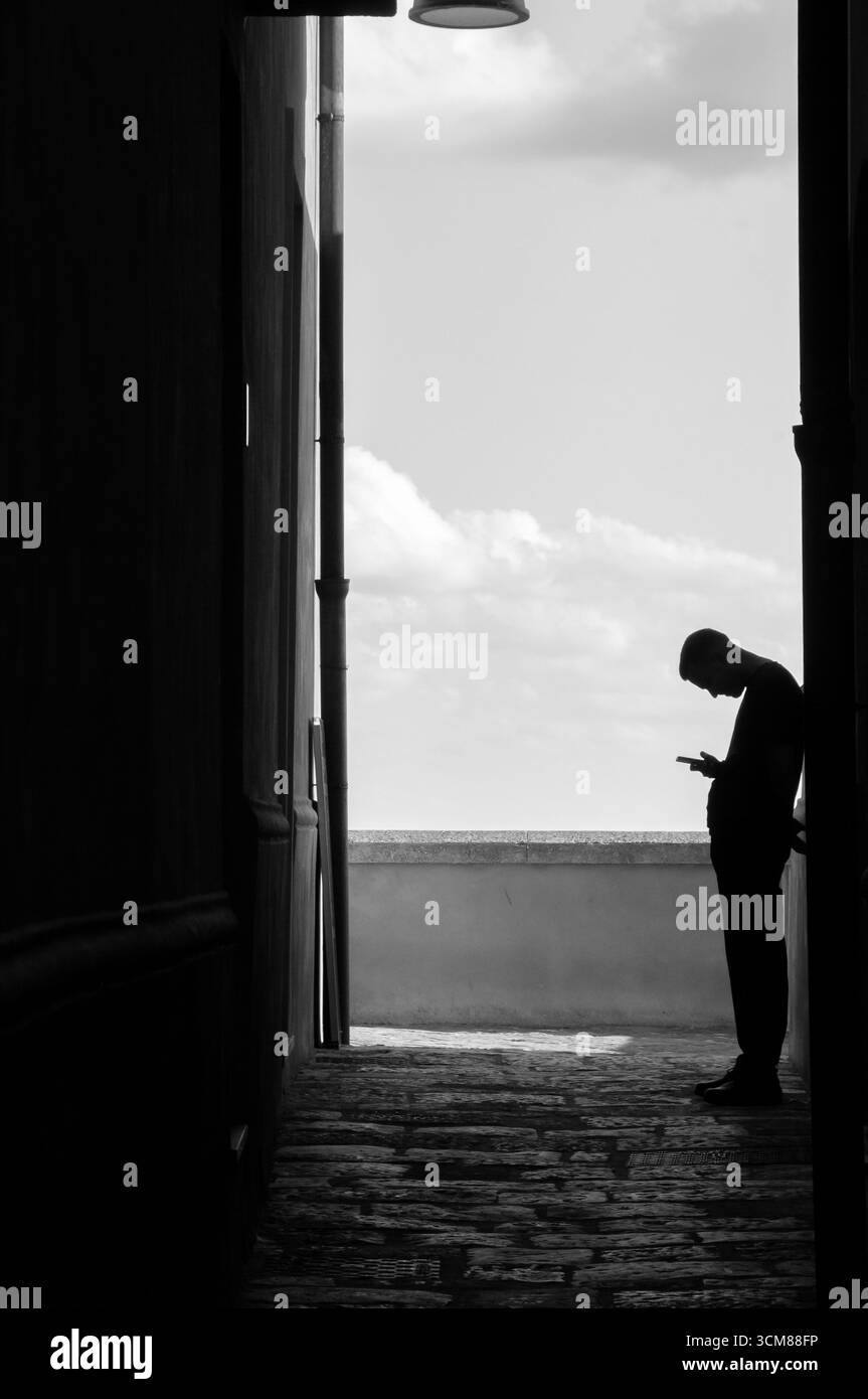 Un garçon regarde son smartphone avec une mauvaise posture Banque D'Images