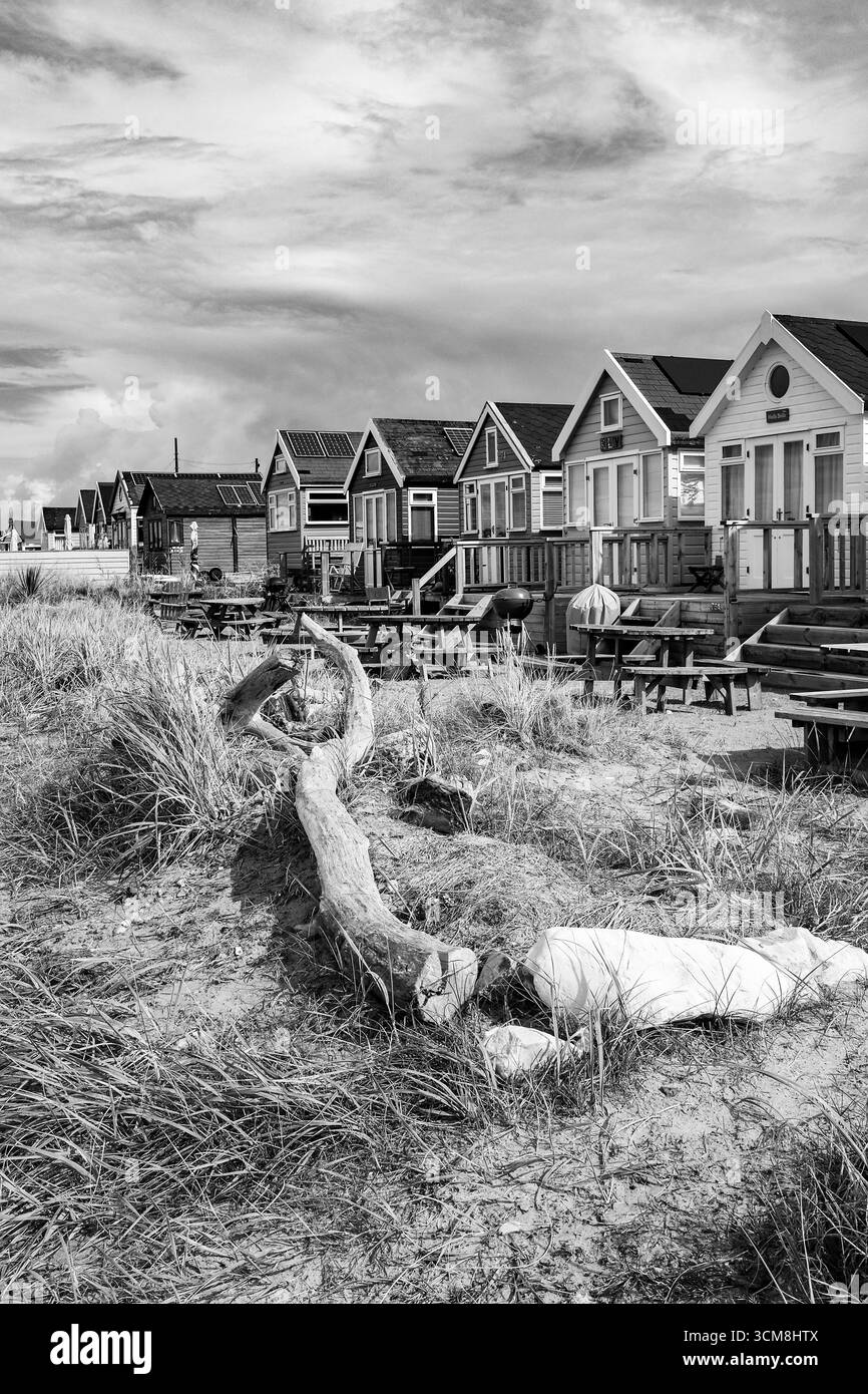Monochrome des célèbres cabanes de plage choliday et maisons de vacances à Hengistbury Head surplombant le port de Christchurch et la mer près de Bournemouth Banque D'Images