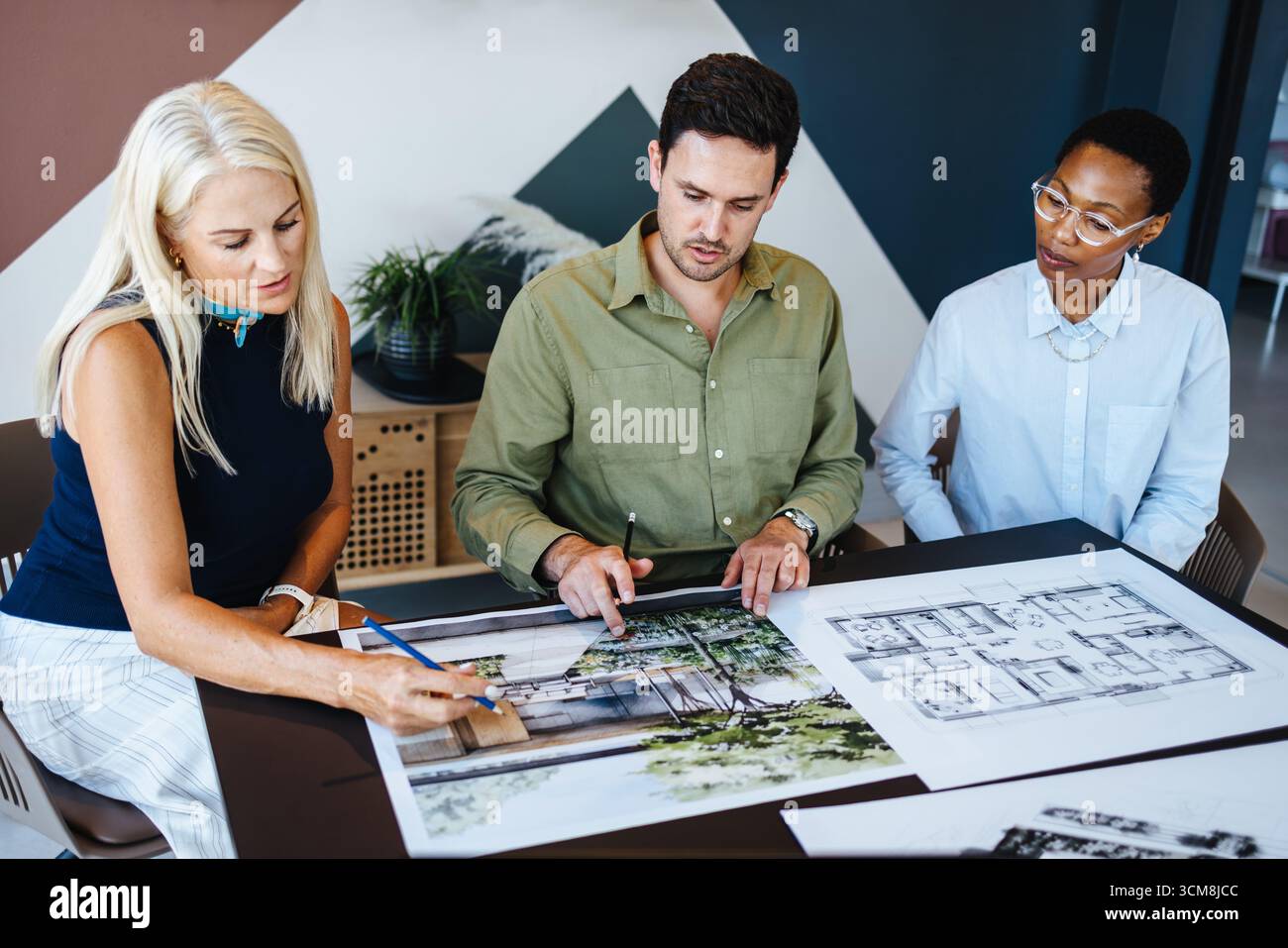 Une équipe de professionnels de différents genres et groupes d'âge s'engageant dans une discussion de conception, examinant les plans architecturaux dans un espace de bureau, fosteri Banque D'Images
