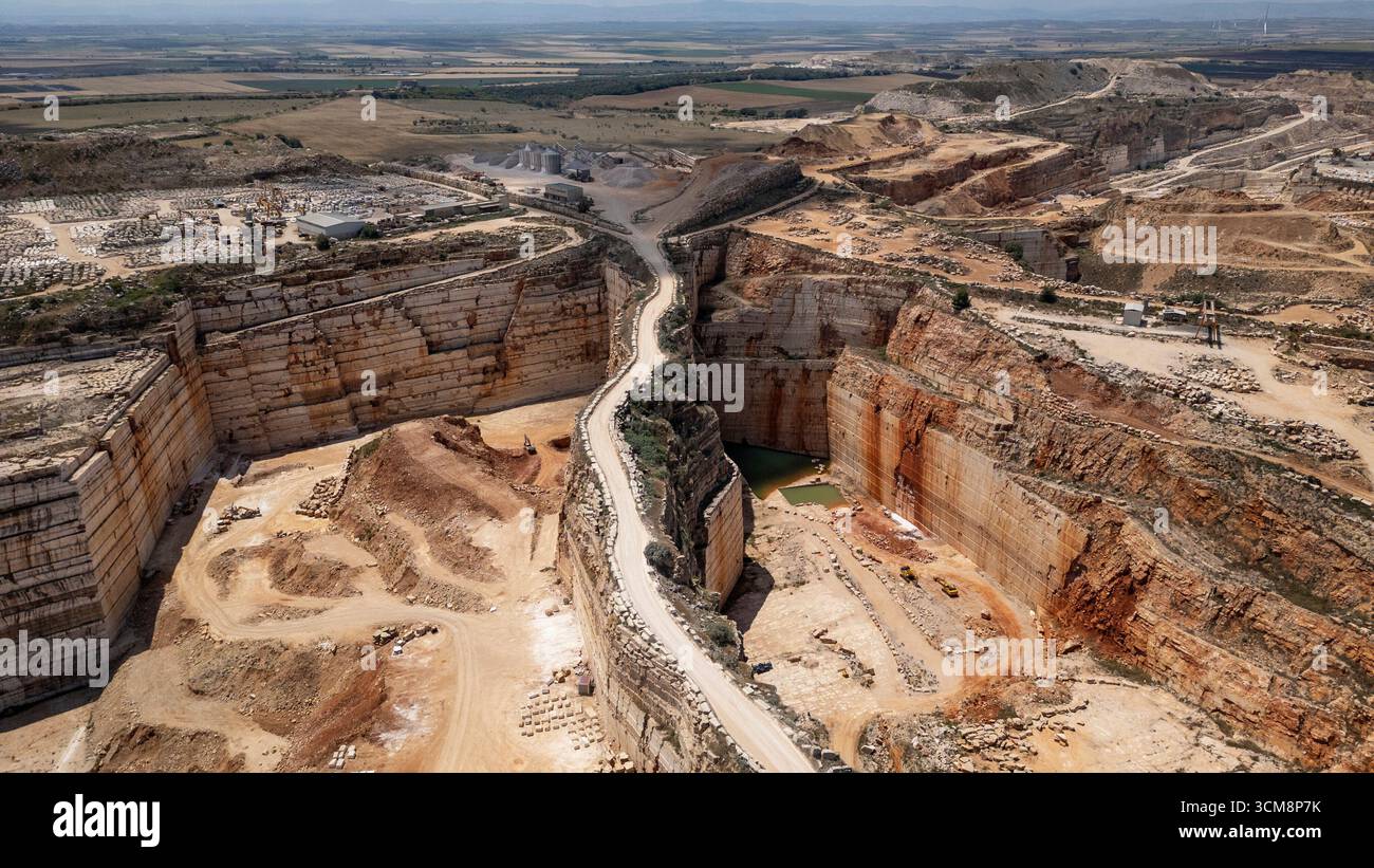 L'image montre un vaste paysage de carrières de pierre et de marbre près d'Apricena dans le sud de l'Italie, caractérisé par des bords profonds et nettement coupés de carrières et des plaines en terrasses. Banque D'Images