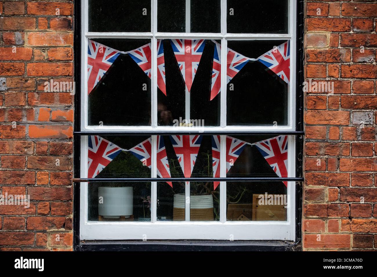 Windsor, Royaume-Uni. 14 septembre 2025. Union Jack Bunting est photographié dans la fenêtre d’une propriété résidentielle avant la deuxième visite d’État du président américain Donald Trump et de la première dame Melania Trump. Le président Trump et son épouse séjourneront au château de Windsor en tant qu’invités du roi Charles III et de la reine Camilla à partir du 17 septembre. Crédit : Mark Kerrison/Alamy Live News Banque D'Images