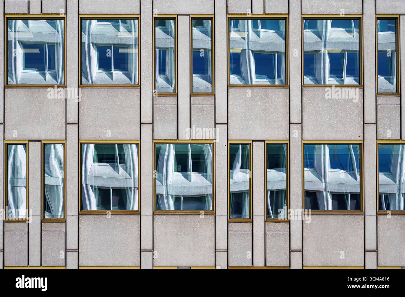 Harmonie réfléchissante : échos urbains. Les fenêtres d'un immeuble de bureaux à Oslo, en Norvège, reflètent les formes déformées d'une structure voisine dans des motifs rythmiques. Banque D'Images