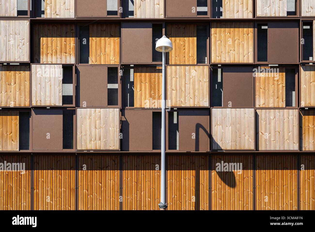 Esthétique moderne du bois : hommage aux éléments historiques. Conçu par Vilhelm Lauritzen Architects, le garage Timber House Orient Plads situé dans le quartier Nordhavn de Copenhague présente une façade en bois et en aluminium recyclé qui imite les poutres en bois empilées, rendant hommage à l'histoire du stockage et du commerce du bois dans la région. Banque D'Images