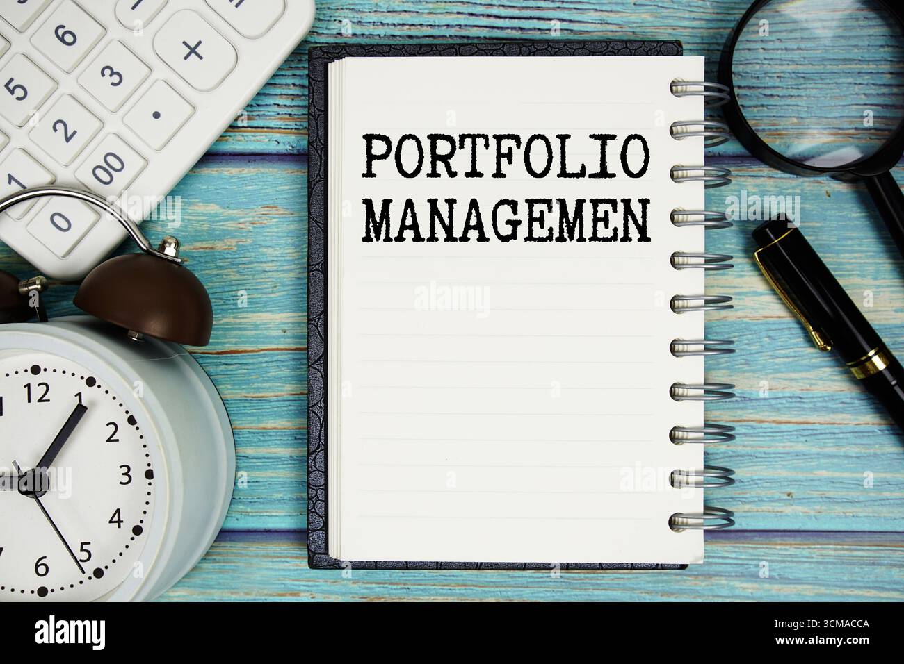 Portfolio Management texte sur bloc-notes avec réveil, loupe et calculatrice sur fond en bois Banque D'Images