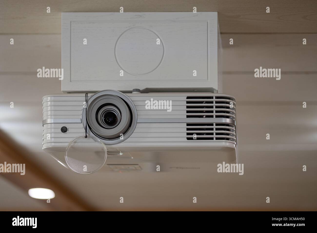 Projecteur blanc moderne monté au plafond avec cache d'objectif dans un intérieur contemporain. Technologie Smart Home, innovation et expérience Home Cinema Banque D'Images