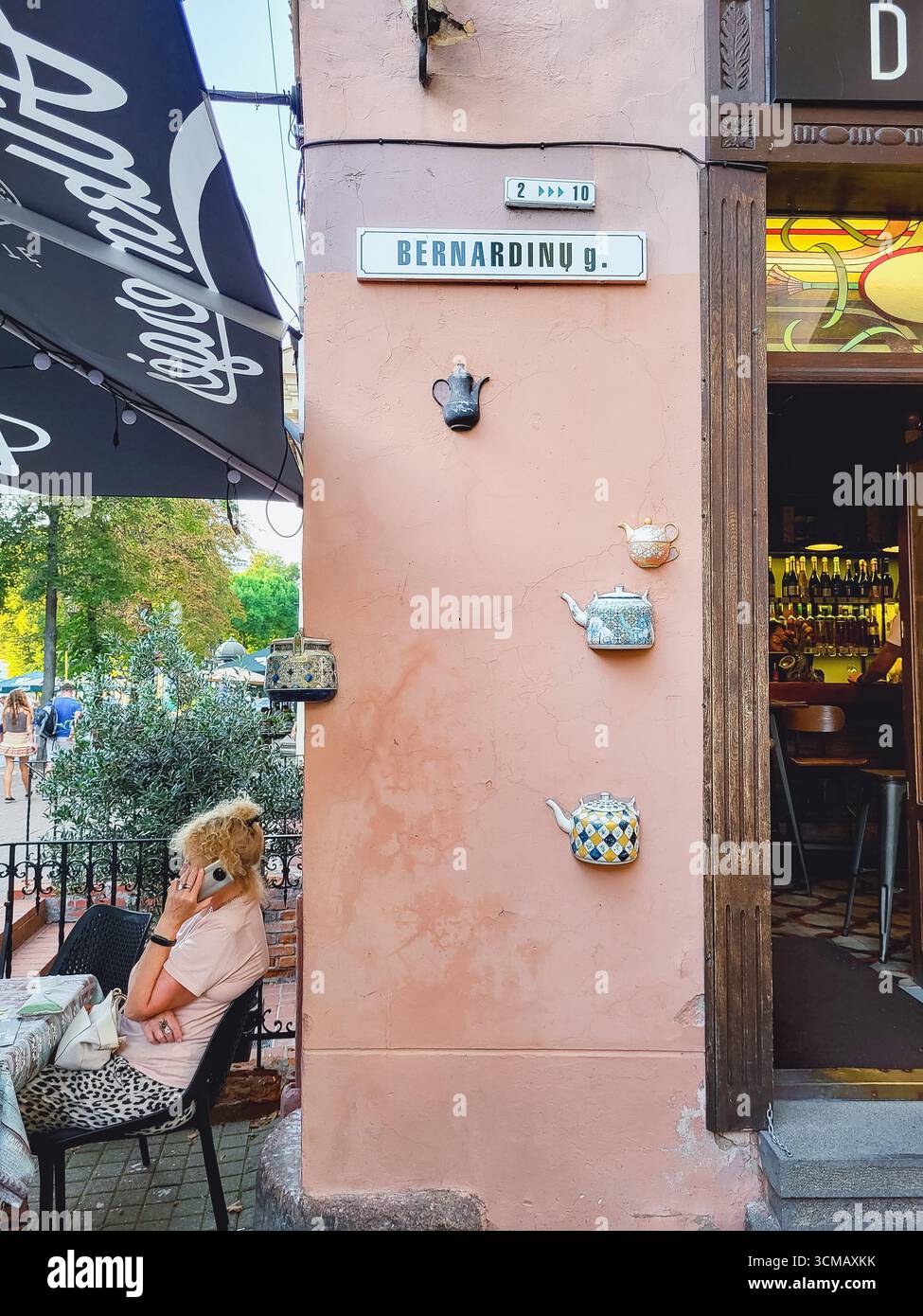 Vilnius, Lituanie - 2022-08-28 - Bernardinu Street dans la vieille ville avec des murs décorés de théières Banque D'Images