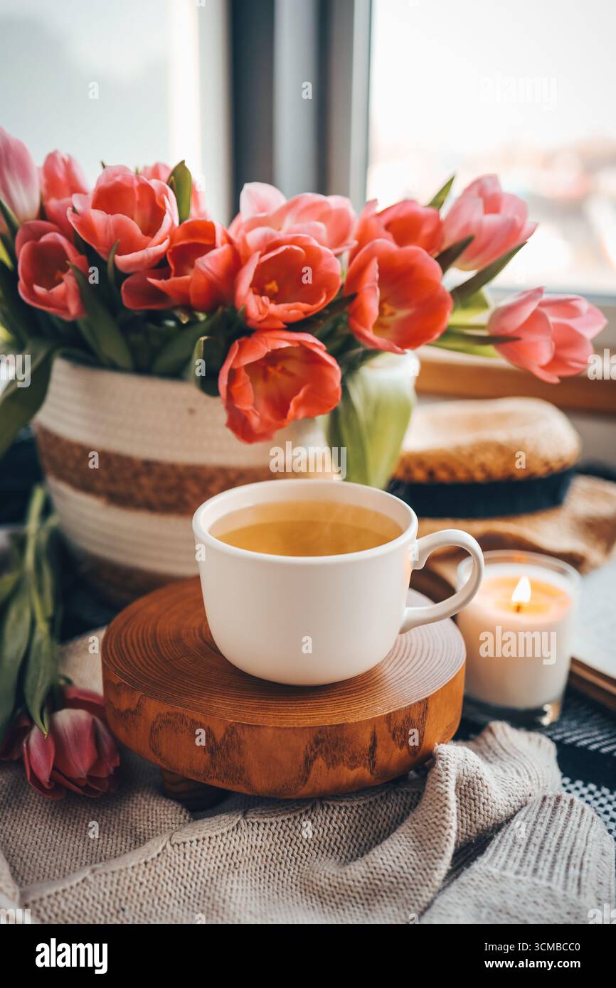 Tasse de thé et panier avec tulipes, nature morte esthétique. Banque D'Images