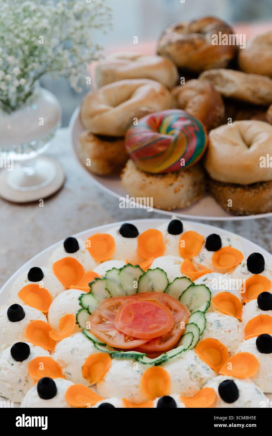Une sélection vibrante de bagels et un plateau de légumes magnifiquement arrangé sont présentés dans un café pendant le brunch. Banque D'Images