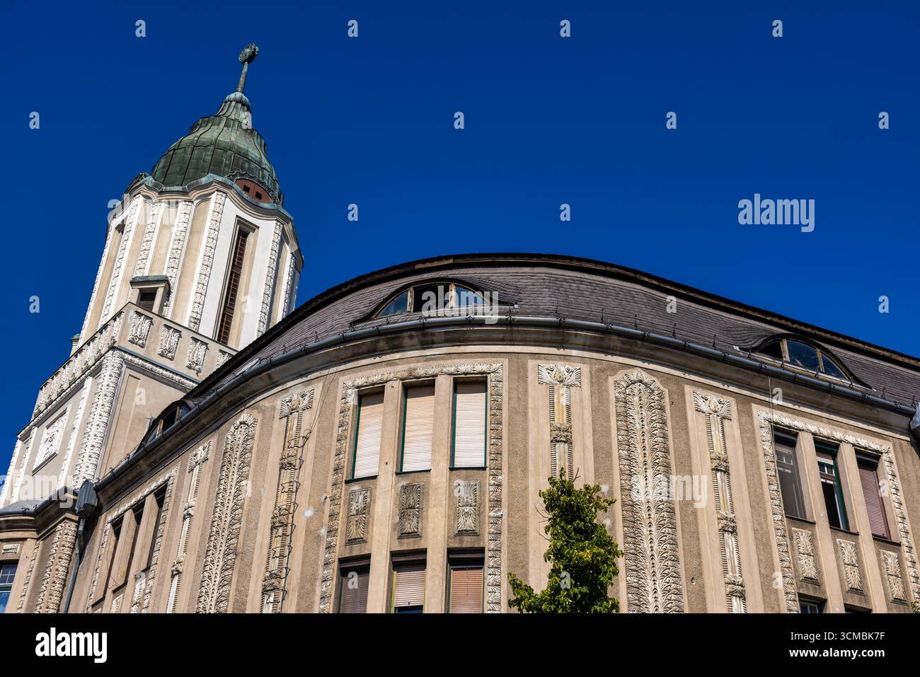 Debrecen, Hongrie 30 juillet 2025 – bâtiment historique orné de pierres sculptées, tour de dôme et façade courbée sous un ciel bleu vif. Banque D'Images